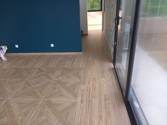 Pose d'un carrelage imitation parquet avec motif au centre toujours dans la vérand