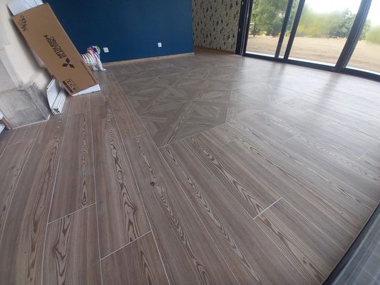 Pose d'un carrelage imitation parquet avec motif au centre toujours dans la vérand