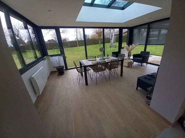Réalisation d'une maçonnerie pour une véranda avec le percement d'un passage entre la maison et la véranda et carrelage style lame à parquet Réalisation d'une maçonnerie pour une véranda avec le percement d'un passage entre la maison et la véranda et carrelage style lame à parquet